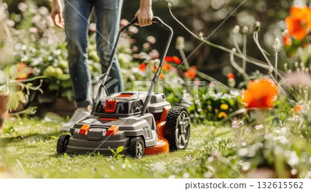 A person is mowing the lawn with a lawnmower in the garden A person is mowing the lawn with a lawnmower in the garden 132615562