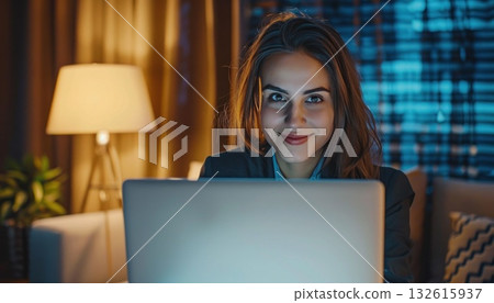 a woman is sitting on a couch using a laptop computer at night a woman is sitting on a couch using a laptop computer at night 132615937