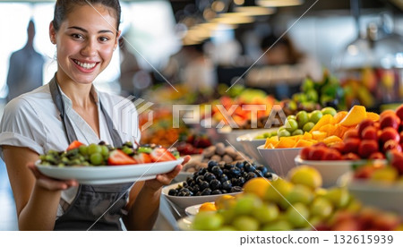 A woman smiles while holding a plate of fresh fruit at the buffet table 132615939