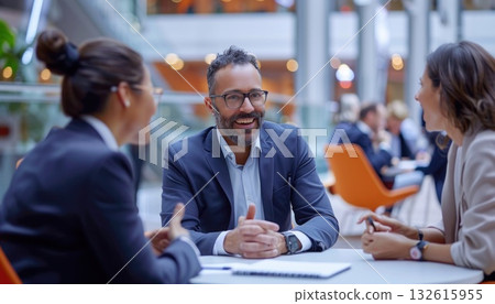 a group of people are sitting at a table having a conversation 132615955