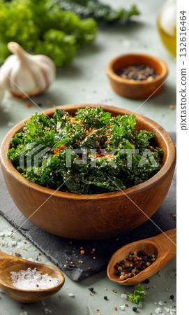 Healthy kale salad with garlic and spices in a wooden bowl on a table 132616464