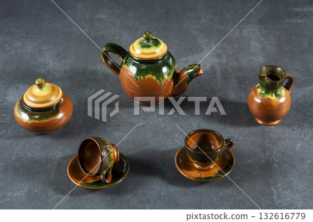 A collection of small tea set pieces, including a teapot, cups, and saucers A collection of small tea set pieces, including a teapot, cups, and saucers 132616779