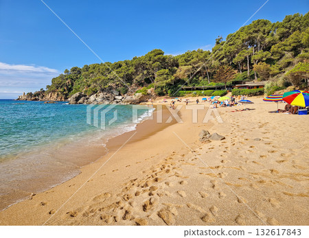 Playa Santa Cristina located in Lloret de Mar on the Costa Brava, Spain. Beautiful beach with fine golden sand and crystal-clear water, sheltered by pine covered cliffs Playa Santa Cristina located in Lloret de Mar on the Costa Brava, Spain. Beautiful beach with fine golden sand and crystal-clear water, sheltered by pine covered cliffs 132617843