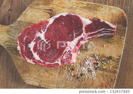 raw rib eye steak, cowboy steak, on a wooden chopping board, top view, no people, raw rib eye steak, cowboy steak, on a wooden chopping board, top view, no people, 132617885