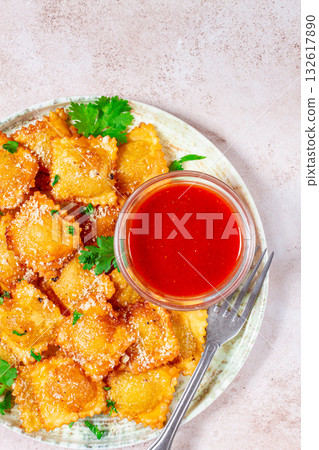 fried ravioli with parmesan cheese, served with red sauce and garnished with herbs, on a light background, no people, fried ravioli with parmesan cheese, served with red sauce and garnished with herbs, on a light background, no people, 132617890