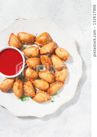 Fried mini chebureks, with sauce, on a decorative plate, hard light, no people, Fried mini chebureks, with sauce, on a decorative plate, hard light, no people, 132617906