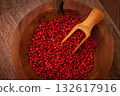 Bright red peppercorns, in a wooden bowl, with a small wooden tray, 132617916