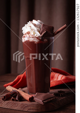 hot chocolate drink, topped with whipped cream, chocolate shavings, and a cinnamon stick hot chocolate drink, topped with whipped cream, chocolate shavings, and a cinnamon stick 132617927