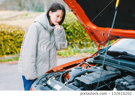一位年輕的女司機，因為她的車拋錨而似乎遇到了麻煩 132618202