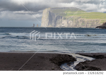 Scenic view of Tjornuvik, a charming village on the north coast of Streymoy, surrounded by dramatic mountains and ocean. Scenic view of Tjornuvik, a charming village on the north coast of Streymoy, surrounded by dramatic mountains and ocean. 132618292