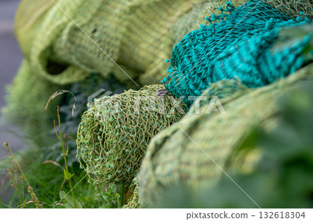Stacked fishing nets in various colors and textures create a vibrant, detailed composition of maritime life. Stacked fishing nets in various colors and textures create a vibrant, detailed composition of maritime life. 132618304
