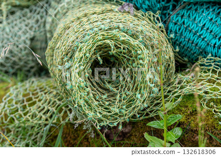Stacked fishing nets in various colors and textures create a vibrant detailed composition of maritime life. 132618306