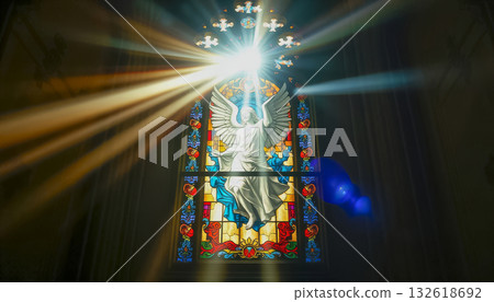 A ray of bright sun passes through the stained glass of the cathedral, as a sign of God, shimmering and shining in the glass, Catholic faith. A ray of bright sun passes through the stained glass of the cathedral, as a sign of God, shimmering and shining in the glass, Catholic faith. 132618692