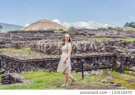 Female tourist standing in front of Teotihuacan pyramids in Mexico, enjoying sightseeing, adventure, and cultural heritage. Travel, tourism, and exploration concept 132618970