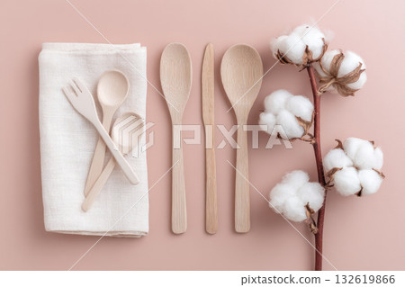 Eco friendly cutlery, cotton napkin, wooden spoon, fork, knife, and cotton branch arranged on pastel background, promoting sustainable lifestyle and natural materials 132619866