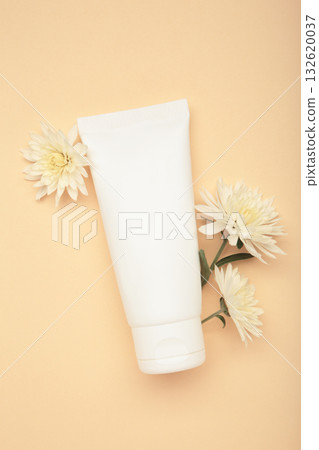 Natural beauty essential. Skincare cream with chrysanthemums on beige background. Vertical photo Natural beauty essential. Skincare cream with chrysanthemums on beige background. Vertical photo 132620037