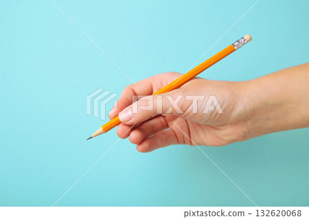 Woman holding pencil on blue background. Space for text 132620068