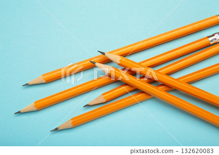 Graphite pencil with eraser on blue background. School stationery Graphite pencil with eraser on blue background. School stationery 132620083