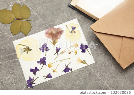 Pressed and dried flowers with twine on grey concrete background. For use in scrapbooking, floristry or herbarium. Pressed and dried flowers with twine on grey concrete background. For use in scrapbooking, floristry or herbarium. 132620086