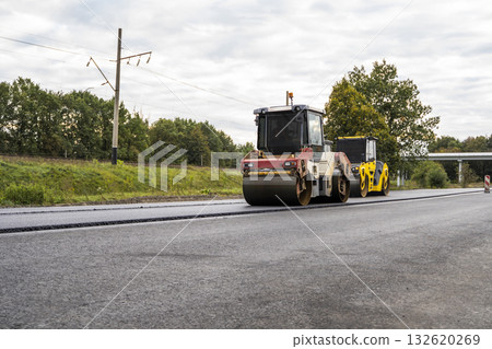 Road rollers compacting new asphalt layer during road construction on countryside highway Road rollers compacting new asphalt layer during road construction on countryside highway 132620269