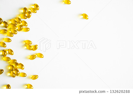 Golden vitamin capsules arranged on white background with copy space Golden vitamin capsules arranged on white background with copy space 132620288