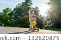 Scooter child. Girl riding scooter toddler. Yellow outdoor activity park road. 132620875