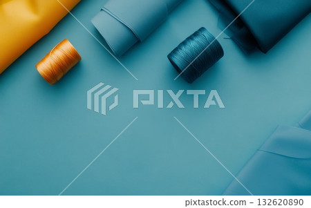 Bright rolls of fabric and threads arranged on a blue background, ideal for sewing and crafting projects Bright rolls of fabric and threads arranged on a blue background, ideal for sewing and crafting projects 132620890
