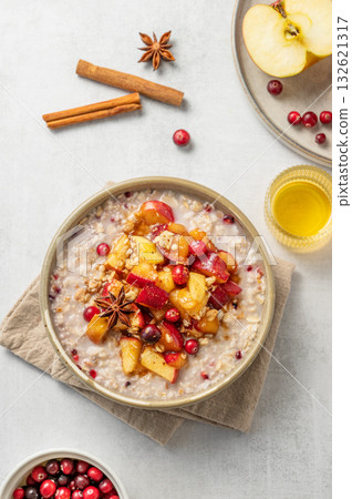 Overnight oatmeal with apple, cranberry and cinnamon in a plate on a light background 132621317