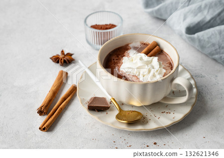 Hot chocolate in a cup with whipped cream and spices on a light background with napkin. 132621346