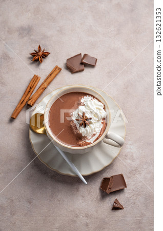Hot chocolate in a cup with whipped cream and spices on a light background. Hot chocolate in a cup with whipped cream and spices on a light background. 132621353