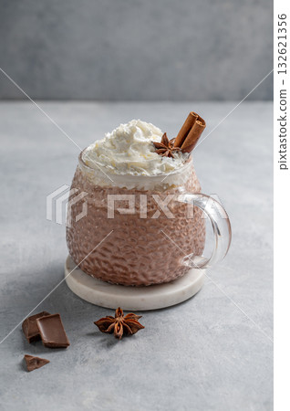 Hot chocolate in a cup with whipped cream and spices on a light background. 132621356