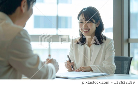 微笑的商務人士正在簽署文件並做筆記 132622199