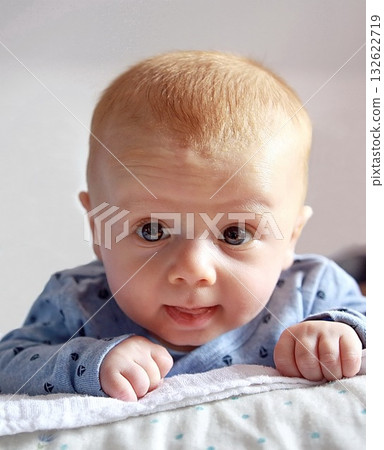 Close-up of an adorable baby with red hair lying on their stomach, 132622719