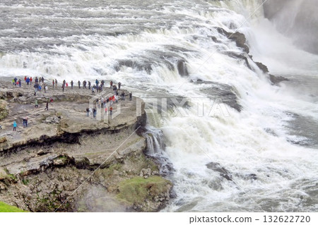 Tourists gather on a rocky outcrop beside the powerful Gullfoss waterfall in Iceland 132622720