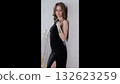 Stylish woman stance, Sophisticated woman in evening dress leaning against textured background, Elegant lady dressed in evening ensemble adopting poised stance against intricately textured 132623259