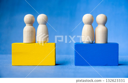 Four wooden pegs on a yellow and blue blocks symbolizing inclusion and leadership with customizable space for text or ideas. 132623331