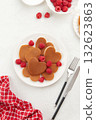 A heap of heart shaped pancakes on the white plate with raspberries on the white background 132623863