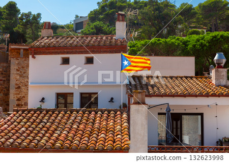 Catalonia flag above tiled house in Tossa de Mar Spain 132623998