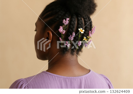 Woman with natural braids adorned with purple wildflowers and daisy wearing lavender dress against neutral background, AI Generative 132624409