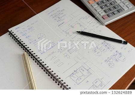 An architect is working on a plan in a grid notebook An architect is working on a plan in a grid notebook 132624889