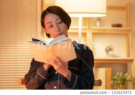 一個女人在晚上看書 132625471