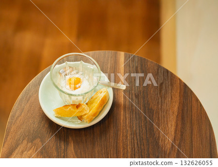 Top view of soft boiled egg with slice of toast on wooden table. 132626055