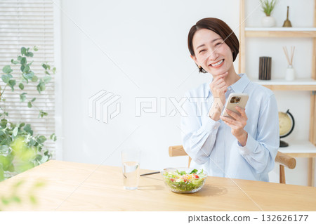 Woman eating salad and smartphone Woman eating salad and smartphone 132626177