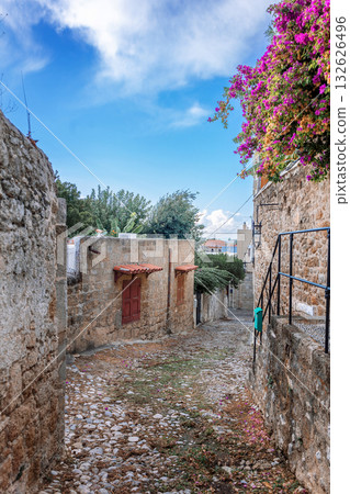 Street view of old town of Rhodes, Greece. Paved roads and pavements with colorful houses and fragrant flowers. High quality photo 132626496