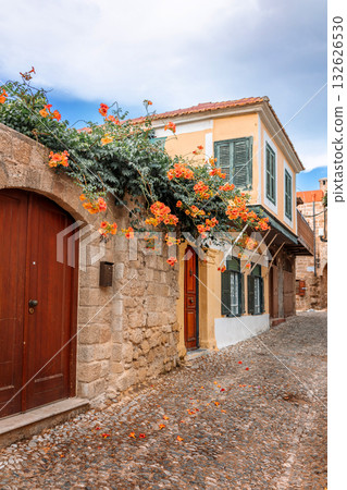 Street view of old town of Rhodes, Greece. Paved roads and pavements with colorful houses and fragrant flowers. High quality photo 132626530