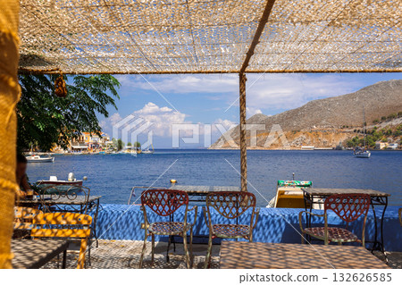 Panoramic view of small haven of Symi island. Village with Street Cafe and colorful houses located on rock.  132626585
