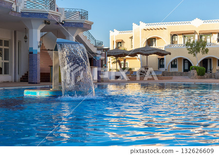 Hydromassage water with gentle splashes at spa resort. Waterfall flow in spa swimming pool. Hydrotherapy, health and skin care. Vacation concept. High quality photo 132626609