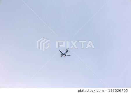 View of airplane flying in gray sky among white clouds. High quality photo 132626705