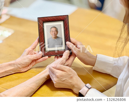 一對老年夫婦正在看相框裡的照片。 132626806