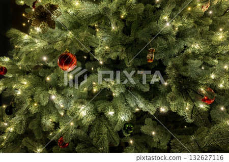 Close-up of a Christmas tree decorated with twinkling lights and colorful ornaments, creating a festive and joyful holiday mood. Close-up of a Christmas tree decorated with twinkling lights and colorful ornaments, creating a festive and joyful holiday mood. 132627116